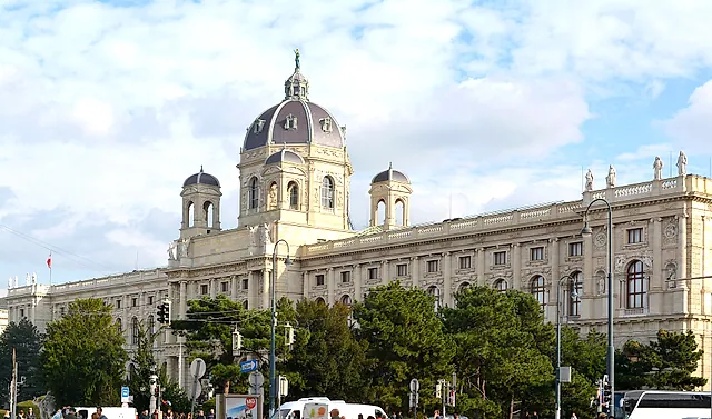 The facade and octagonal dome of the Kunsthistorisches Museum under white clouds